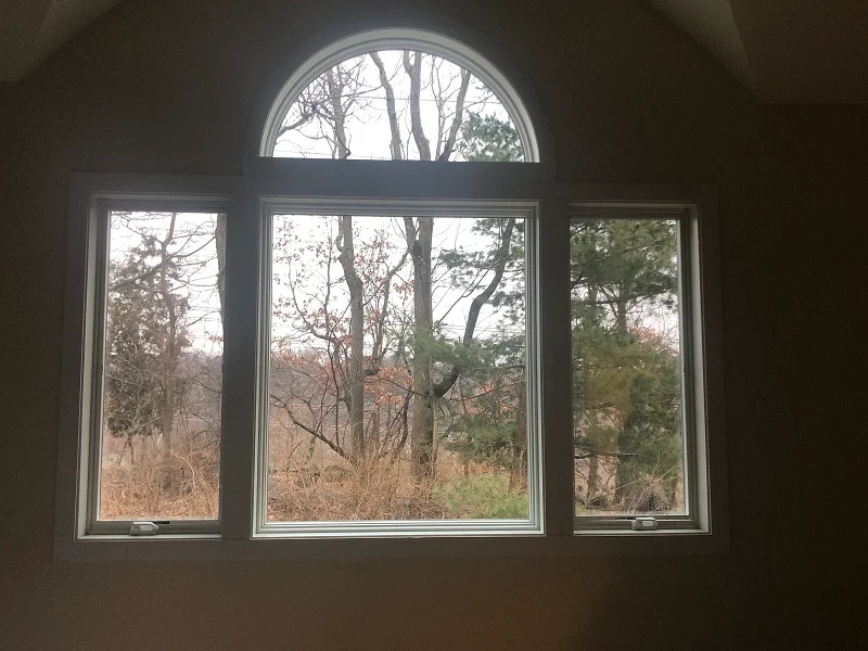 Interior trim around Andersen 400 Series casement and half round window installed by Window Solutions Plus